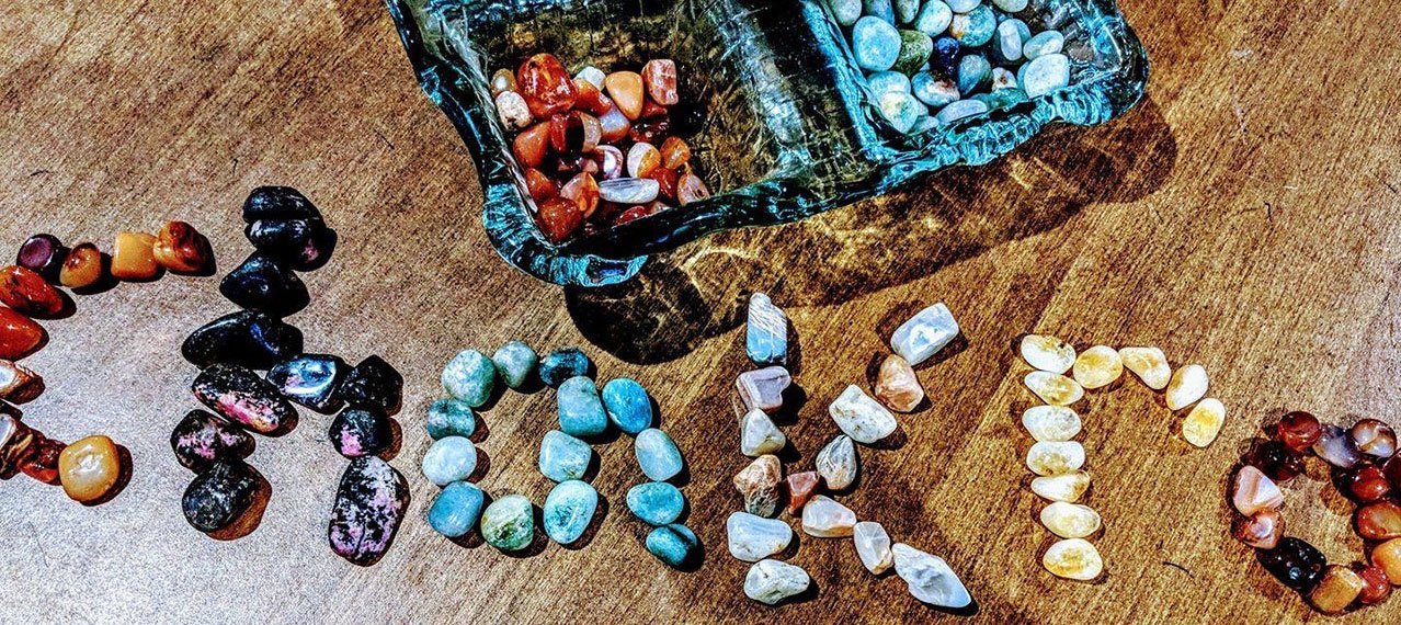 collection of colorful stones, some of which are assembled to spell out the word chakra
